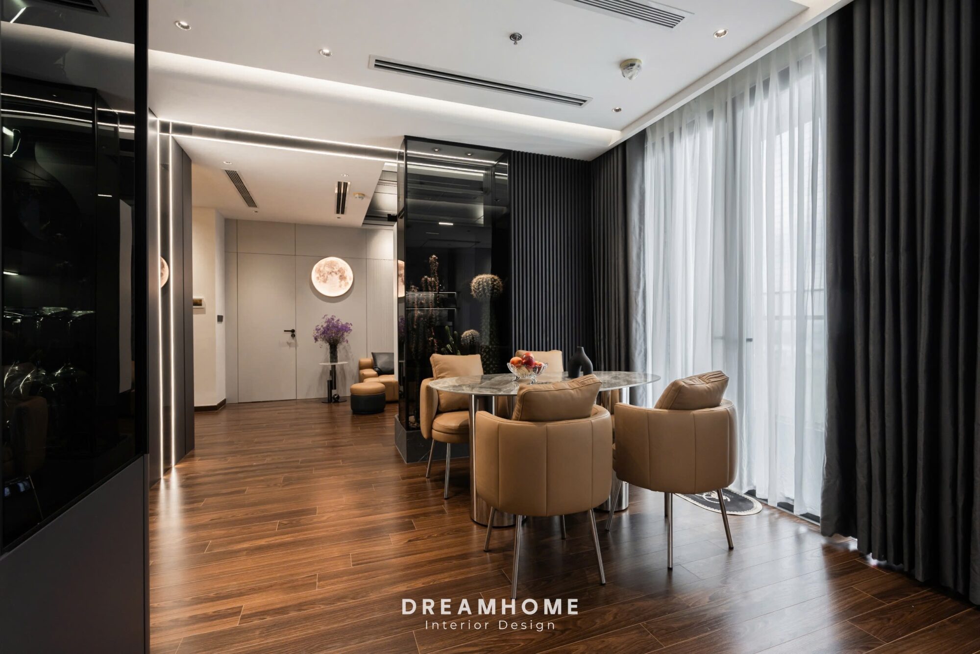 Hoàn Thiện Công Trình Thực Tế Masteri West Heights - 120M2 6 Cạnh bàn ăn là một tấm kính lớn, cho phép ánh sáng tự nhiên tràn vào không gian